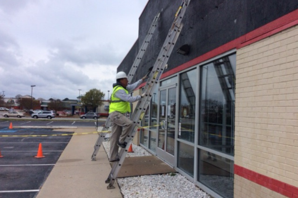 Commercial Painter climbing ladder to paint building